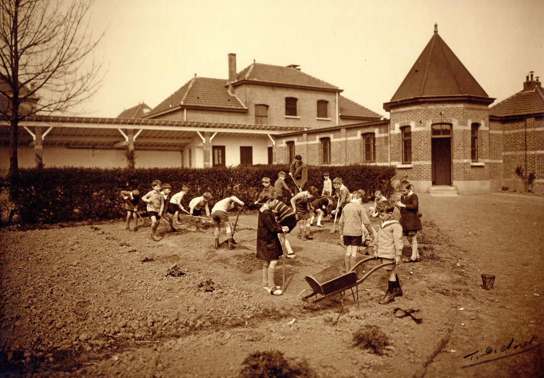 La première école du Karrenberg. Les enfants sont initiés au jardinage par leur instituteur R. Dewilder - Photo vers 1930 (Espace Mémoire coll. R. Nevens)